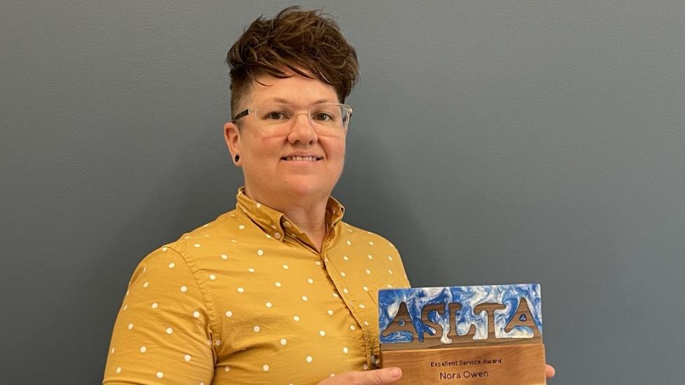 Nora Owen holding an ASLTA award